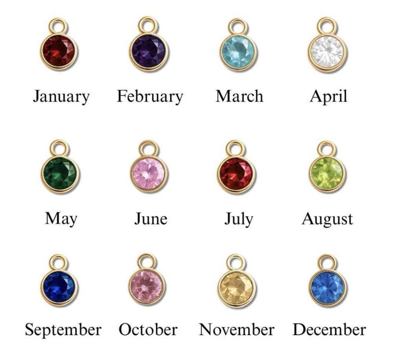 May include: A collection of twelve gold-colored pendants, each featuring a different colored gemstone. Each pendant is labeled with a month of the year, from January to December. The gemstones are various colors, including red, purple, blue, and green.