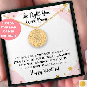 May include: A gold necklace with a round pendant featuring a custom star map. The necklace comes in a pink and white box with the text "The Night You Were Born" and "Happy Sweet 16!" The box also includes the text "Custom Star Map of Her Birthday".