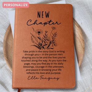 May include: A personalized, orange-brown journal with the words "NEW Chapter" in elegant script. The cover features a floral design and inspirational text. The journal includes a ribbon bookmark.
