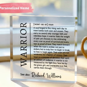 May include: A clear acrylic block with the word "WARRIOR" printed vertically on the left side. The block contains a definition of "warrior" and the name "Richard Williams" at the bottom. A pink rectangle with the words "Personalized Name" is at the top.