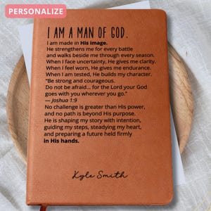 Pu&ograve; includere: Un diario in pelle marrone con il testo "I AM A MAN OF GOD" e un nome personalizzato. Il diario include un testo ispiratore da Giosu&egrave; 1:9. &Egrave; visibile un segnalibro a nastro rosso. La parola "PERSONALIZZA" &egrave; in una casella rosa in alto a sinistra.