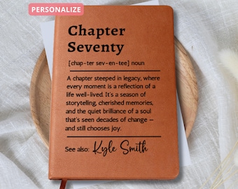 May include: A personalized, brown leather journal with the text "Chapter Seventy" and a definition. The journal includes the text "See also: Kyle Smith" and a red ribbon bookmark. The word "PERSONALIZE" is in a pink box in the upper left corner.