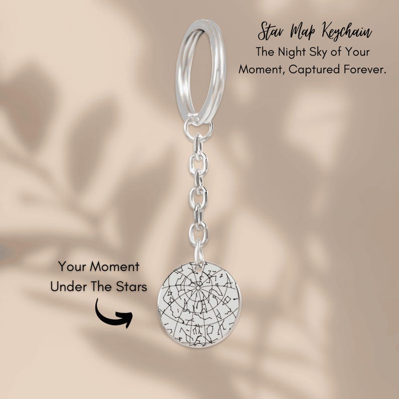 Pu&ograve; includere: Un portachiavi argentato con mappa stellare con un ciondolo circolare raffigurante una dettagliata carta stellare. Il portachiavi include il testo "Star Map Keychain" e "The Night Sky of Your Moment, Captured Forever."
