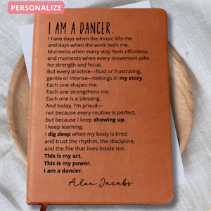 May include: A brown leather journal with the text "I AM A DANCER" and a poem about dance. The journal has a ribbon bookmark and the name "Alex Jacobs" is signed at the bottom. The word "PERSONALIZE" is in a pink box at the top.
