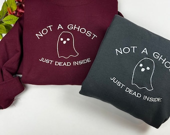May include: Two sweatshirts, one maroon and one dark gray, with the same white embroidered design. The design features a ghost with the text "Not a ghost, just dead inside".
