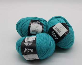 May include: Three balls of teal blue yarn with labels that read "Mare" and "L'Atelier" in black text.