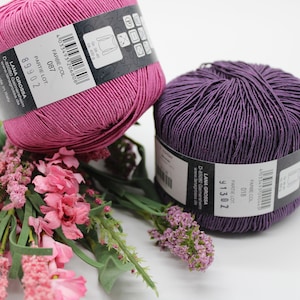 May include: Two skeins of yarn, one pink and one purple, with the brand name "LANA GROSSA" and the color and lot numbers printed on the labels.