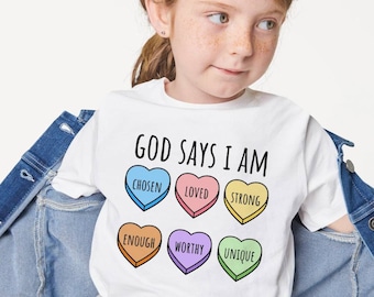 May include: White t-shirt with the text "God Says I Am" and six colorful hearts with the words "Chosen", "Loved", "Strong", "Enough", "Worthy", and "Unique" inside.