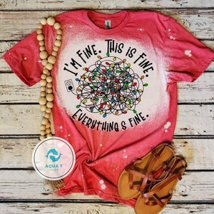 May include: Red t-shirt with a bleached design featuring a tangled string of Christmas lights and the text "I'm fine. This is fine. Everything's fine."