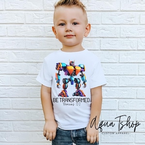 May include: White t-shirt with a colorful robot graphic and the text "BE TRANSFORMED Romans 12:2".