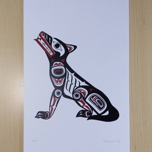 May include: A print featuring a stylized wolf in black, white, and red. The wolf is depicted in a seated position with its head raised and mouth open. The print includes the text "Wolf" and the artist's signature.
