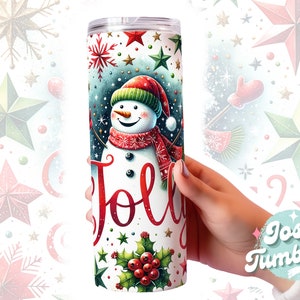 May include: A white tumbler with a snowman design and the word "Jolly" in red lettering. The snowman is wearing a red and white scarf and a red hat. The background is a blue and green pattern with stars and snowflakes.