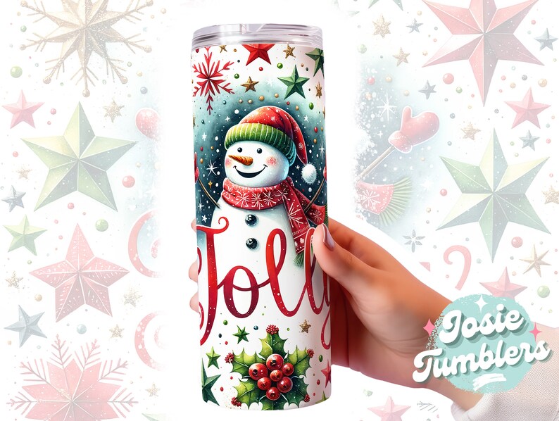 May include: A white tumbler with a snowman design and the word "Jolly" in red lettering. The snowman is wearing a red and white scarf and a red hat. The background is a blue and green pattern with stars and snowflakes.