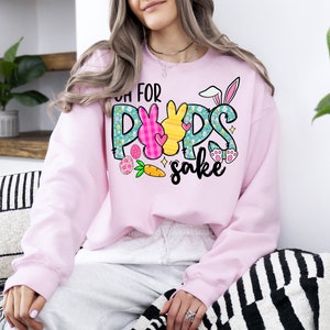 May include: Pink sweatshirt with a graphic of Easter bunnies and the text "Oh for pups sake".