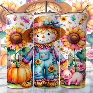 May include: Three stainless steel tumblers with a whimsical autumn theme. The designs feature a scarecrow, sunflowers, pumpkins, and a pig. The scarecrow wears a straw hat and dungarees. The background includes a white picket fence and colourful foliage.