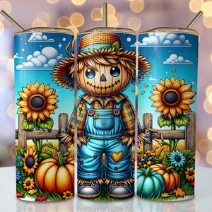 May include: A blue and yellow fall-themed tumbler with a cartoon scarecrow wearing a plaid shirt and overalls. The scarecrow is standing in front of a fence with sunflowers and pumpkins.