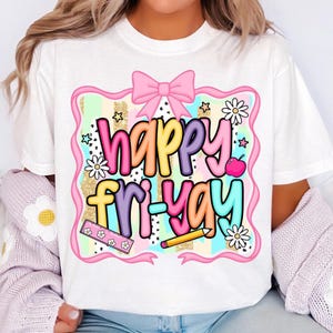 May include: White t-shirt with a colorful graphic that says "happy fri-yay." The design includes a pink bow, stars, daisies, an apple, a ruler, and a pencil. The text is in various colors, including pink, yellow, purple, and blue.