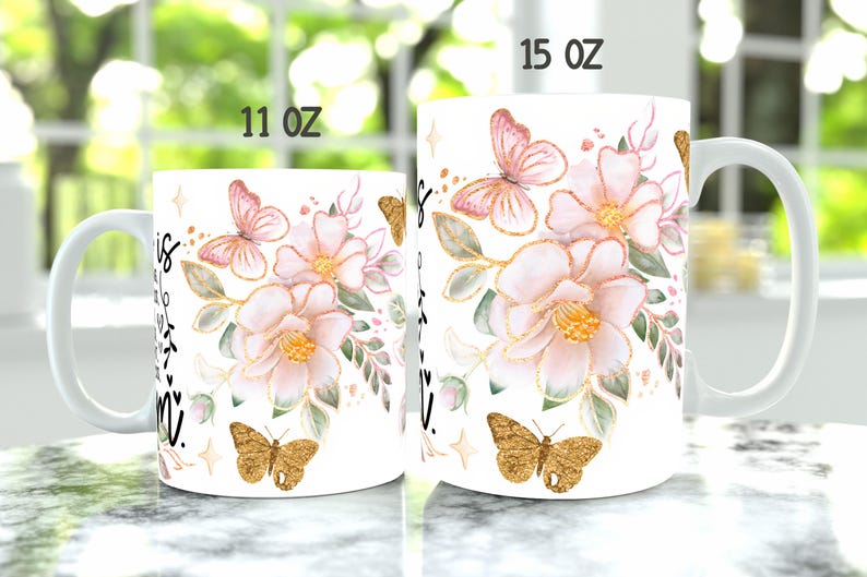 May include: Two white ceramic mugs with floral designs and gold accents. The mugs are 11 oz and 15 oz. The design features pink flowers, green leaves, and gold butterflies.