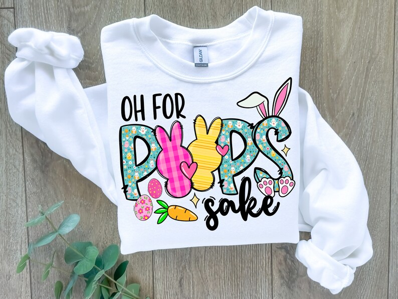 May include: White sweatshirt with a graphic design of Easter bunnies and the text "Oh for pups sake".