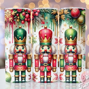 以下が含まれることがあります： クリスマスのナッツクラッカーのデザインが施された白いタンブラーが3つ。各タンブラーには、赤と緑の制服を着た異なるナッツクラッカーが描かれており、金色の王冠、雪片と緑色の背景が描かれています。