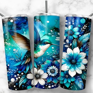 May include: Three stainless steel tumblers with different designs. The first tumbler features a blue and green hummingbird with white flowers. The second tumbler features a blue and green hummingbird with white flowers. The third tumbler features blue and white flowers.