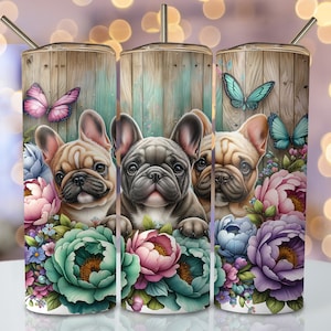 Könnte beinhalten: Drei französische Bulldoggen, die hinter einem bunten Blumenarrangement hervorlugen. Die Hunde sind braun, schwarz und weiß. Die Blumen sind rosa, lila, blau und grün. Der Hintergrund ist eine Holzplankenwand mit einem türkisfarbenen Anstrich.
