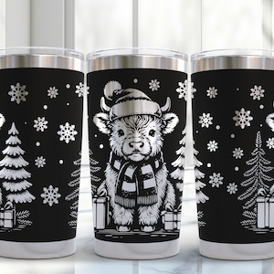 Könnte beinhalten: Drei Edelstahlbecher mit schwarzem Hintergrund und einem weißen Design einer schottischen Hochlandkuh mit Weihnachtsmütze und Schal, einem Weihnachtsbaum und Schneeflocken.