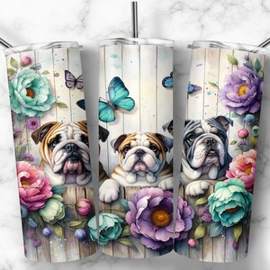 Op de afbeelding: Drie roestvrijstalen bekers met een bloemenontwerp en een bulldog die achter de bloemen uitkijkt. De bloemen zijn in tinten roze, paars, blauw en groen. Vlinders vliegen rond de bloemen.
