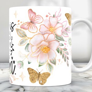 May include: White ceramic mug with a floral design featuring pink and gold butterflies. The mug has a black inscription that reads "This is my happy place".