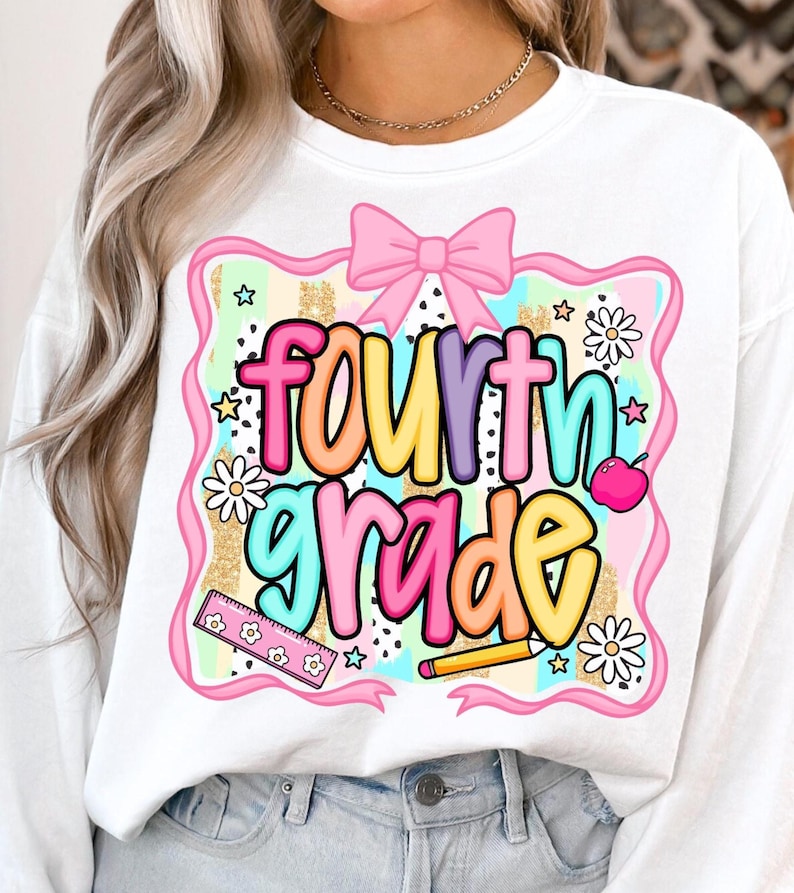 May include: White sweatshirt with a colorful "fourth grade" graphic. The design includes a pink bow, daisies, stars, a ruler, a pencil, and an apple. The text is in a variety of bright colors, perfect for back-to-school.