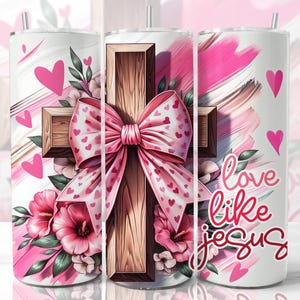 May include: A white tumbler featuring a pink and brown cross, a pink bow, and pink flowers. The tumbler displays the text "love like jesus".