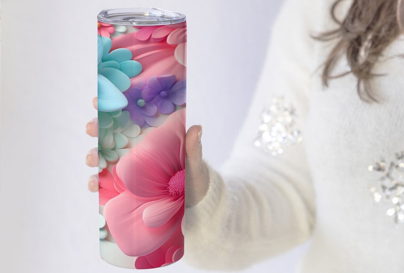 May include: A stainless steel tumbler with a colorful floral design. The design features pink, blue, and purple flowers with a 3D effect.