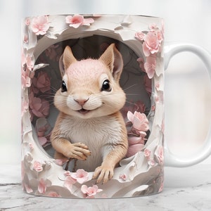May include: A white ceramic mug with a handle features a colourful illustration of a squirrel peeking out of a hole surrounded by pink flowers.
