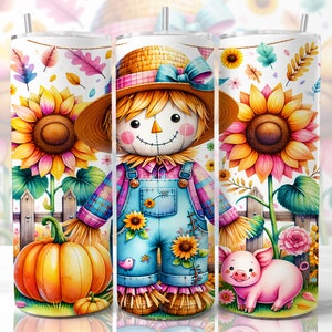 May include: A white tumbler with a watercolour design featuring a scarecrow, sunflowers, a pumpkin, and a pig. The scarecrow wears a straw hat, overalls, and a plaid shirt. The design includes autumn leaves and flowers, creating a seasonal theme.