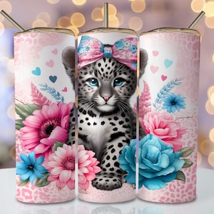 May include: A white and grey leopard cub with a pink bow sits in the centre of a tumbler design. The background is pink with a leopard print pattern and features pink, blue and white flowers.