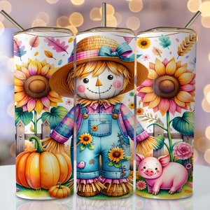 May include: A tumbler with a charming autumnal theme. The design showcases a scarecrow in dungarees, sunflowers, pumpkins, and a pig. The tumbler includes a straw and a lid. The background features a white fence and colourful leaves.