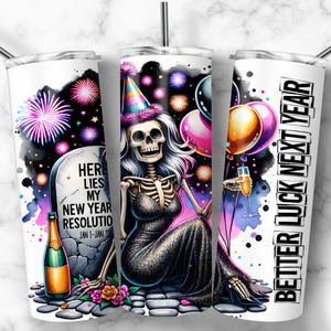 Pode incluir: Caneca branca com um design festivo com um esqueleto com um chap&eacute;u de festa, fogos de artif&iacute;cio, bal&otilde;es e uma garrafa de champanhe. O texto na caneca diz "Here Lies My New Year Resolution" e "Better Luck Next Year."
