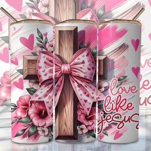 May include: A white tumbler featuring a pink and brown cross, a pink bow with white hearts, and pink flowers. The tumbler displays the text "Love like Jesus".