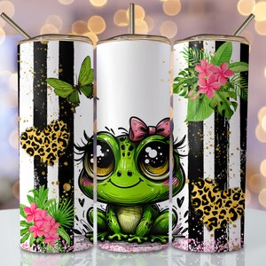 May include: Three stainless steel tumblers with a black and white striped background. The center tumbler features a cartoon frog with big eyes and a pink bow. The left tumbler has a butterfly and a leopard print heart. The right tumbler has tropical flowers and a leopard print heart.