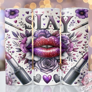 May include: A white tumbler with a purple, red, and glitter design. The tumbler features a lipstick, a makeup brush, and the word "SLAY" in bold letters. The design is surrounded by flowers and hearts.