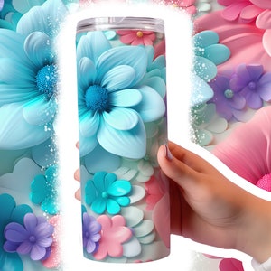 May include: A stainless steel tumbler with a colorful floral design. The tumbler features a variety of flowers in shades of blue, pink, and purple.