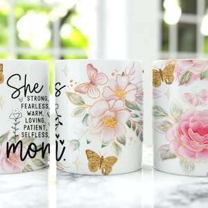 May include: White ceramic mug with a floral design featuring pink and gold butterflies. The mug has a black text that reads "She's strong, fearless, warm, loving, patient, selfless, mom."