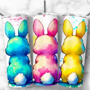 Op de afbeelding: Drie roestvrijstalen bekers met een witte achtergrond en aquarel konijnenontwerpen. De konijnen kijken weg van de kijker en zijn in tinten blauw, roze en geel.