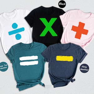 Peut inclure: Cinq t-shirts de couleurs différentes avec des symboles mathématiques imprimés dessus. Les symboles sont un signe de division, un signe de multiplication, un signe d'addition, un signe d'égalité et un signe moins. Les couleurs des t-shirts sont blanc, noir, rose, sarcelle et marine.