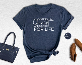 May include: Navy blue t-shirt with white text that reads "Sisters in Christ are sisters for life".