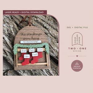 May include: A laser-ready digital download file for a wooden ornament featuring an arched design with the text The stockings were hung and THE WILLIAMS FAMILY. It includes a green garland, five red stockings with white name tags for Dad, Mom, Kendall, Peyton, and Nash, and a brown leather hanging cord.