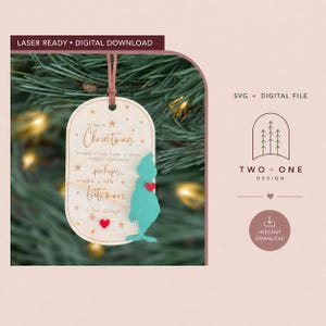 Könnte beinhalten: Ein helles, ovales Holzornament mit dem Text "maybe Christmas doesn't come from a store, maybe Christmas perhaps... means a little bit more - The Grinch", einer türkisfarbenen Figuren-Silhouette und zwei kleinen roten Herzen.