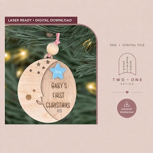 May include: A circular wooden ornament featuring a crescent moon design with engraved stars and the text Baby's First Christmas 2022. A light blue star cutout with the name Ava is attached. The ornament hangs from a pink string with a wooden bead.