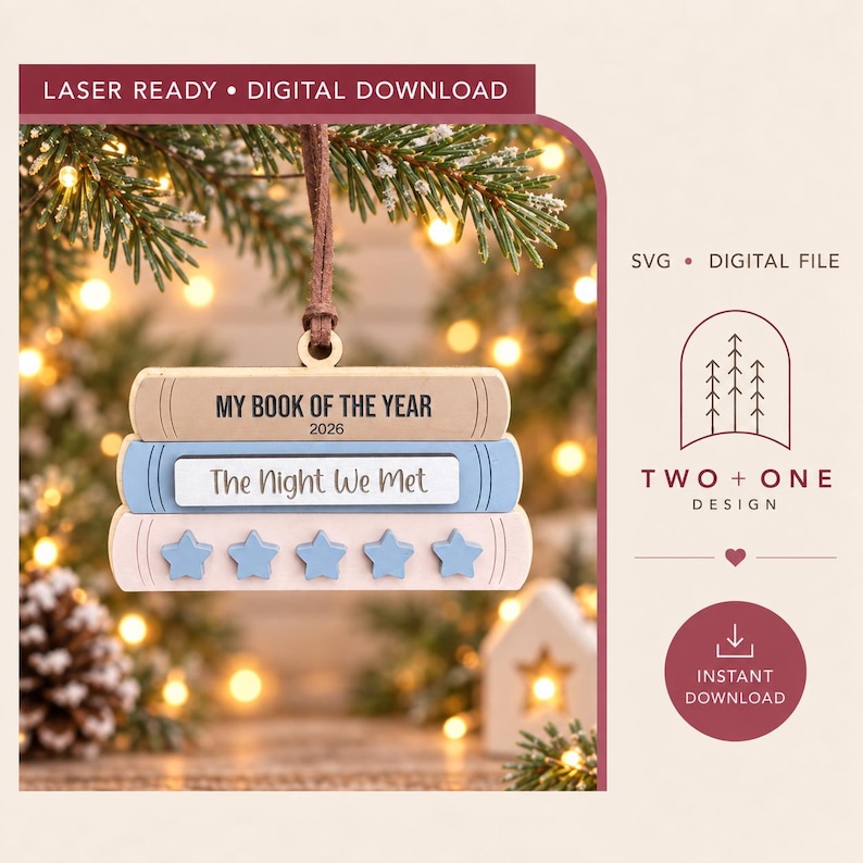 May include: A wooden ornament shaped like a stack of three books, featuring the text MY BOOK OF THE YEAR 2026 on the top book, The Night We Met on the middle book, and five blue star shapes on the bottom book, suspended by a brown cord.