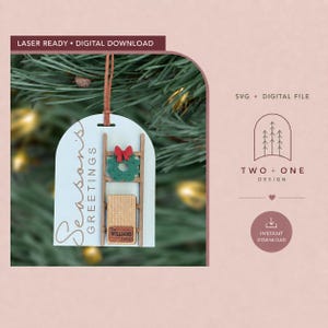 Könnte beinhalten: Ein bogenförmiger Anhänger mit dem Text Season's Greetings, einer Holzleiter, einem grünen Kranz mit roter Schleife und einem kleinen rechteckigen Schild mit der Aufschrift The Williams Family. Laserfertige digitale Datei für Dekorationen.